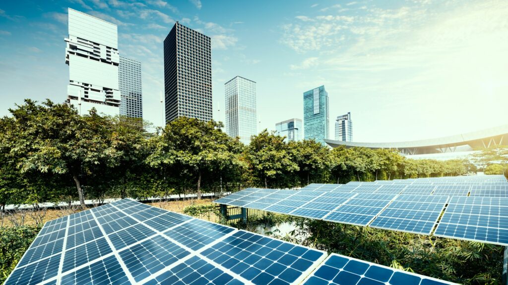 Placas solares en un parque solar urbano con edificios modernos en el fondo